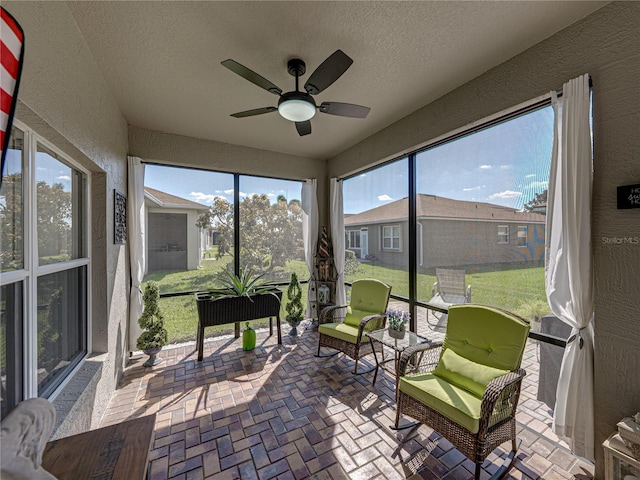 sunroom / solarium featuring a ceiling fan and a wealth of natural light