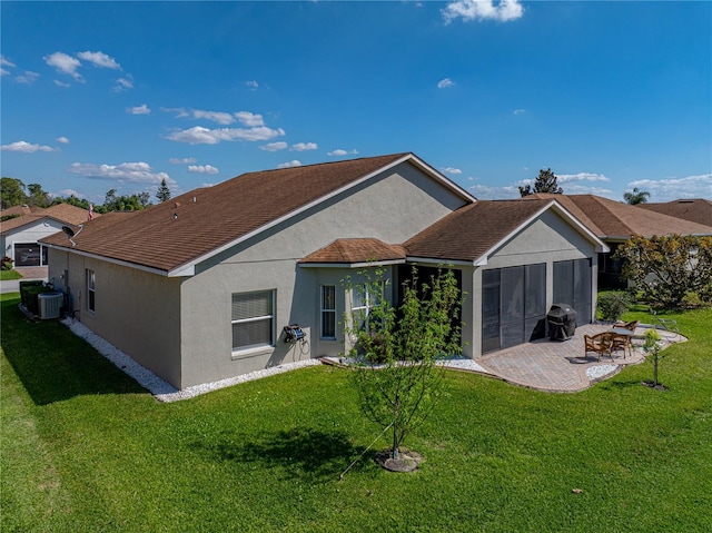 rear view of property with central air condition unit, a patio, a lawn, and stucco siding