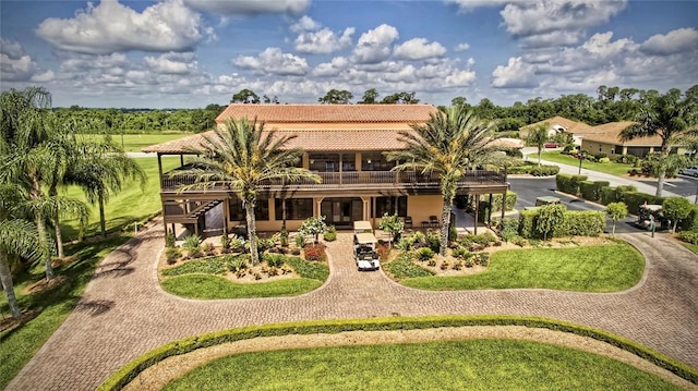 rear view of house with a tile roof, a lawn, and stucco siding