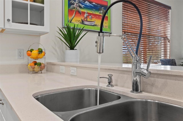 interior details with white cabinetry and a sink