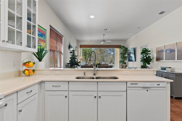 kitchen featuring dishwasher, light countertops, a sink, and white cabinets