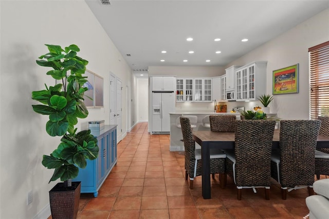 dining area with baseboards, light tile patterned flooring, and recessed lighting