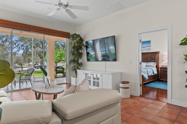 living area with visible vents, ceiling fan, baseboards, and light tile patterned flooring