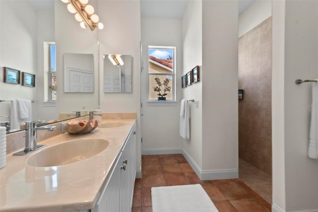 full bathroom featuring double vanity, tile patterned flooring, a sink, and baseboards