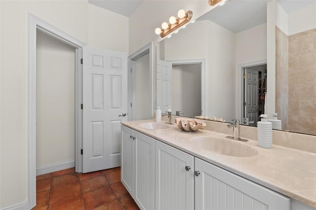 full bathroom with double vanity, a sink, and baseboards