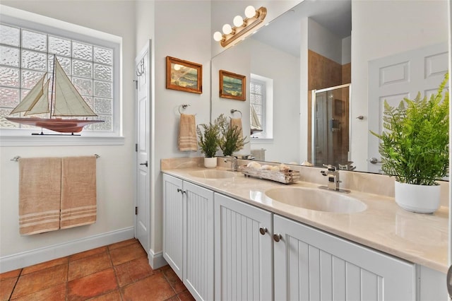 bathroom featuring a healthy amount of sunlight, double vanity, and a sink