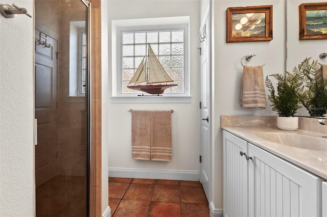 bathroom featuring a stall shower, tile patterned flooring, baseboards, and vanity