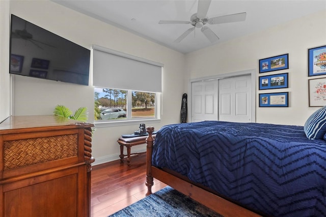 bedroom with a closet, ceiling fan, baseboards, and wood finished floors