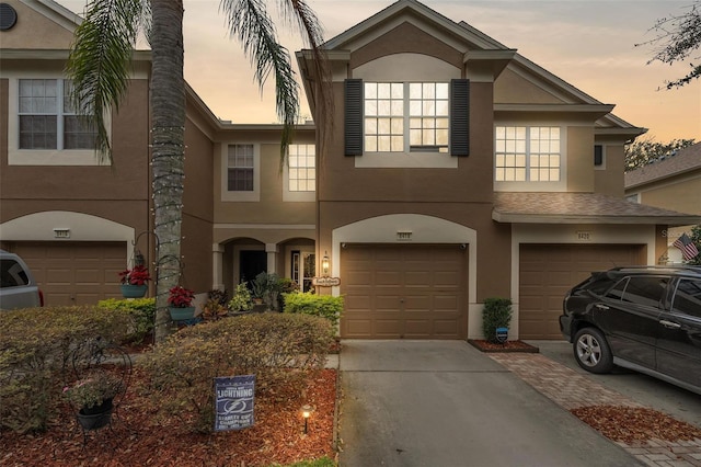 view of front of property with driveway, an attached garage, and stucco siding