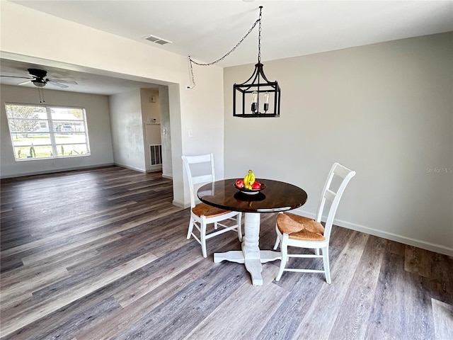 dining area featuring baseboards, visible vents, ceiling fan, and dark wood-style flooring
