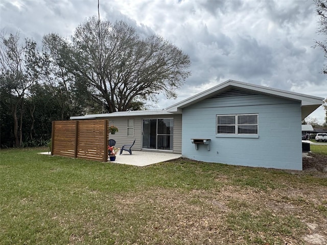 back of house with a yard and a patio area