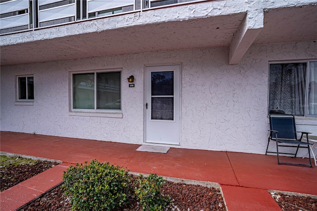 doorway to property featuring stucco siding