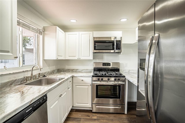 kitchen featuring dark wood-style flooring, appliances with stainless steel finishes, white cabinets, and a sink