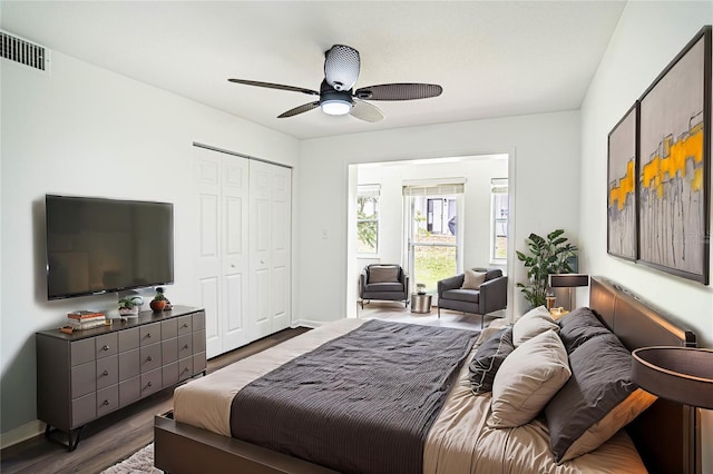 bedroom featuring baseboards, a closet, visible vents, and dark wood-type flooring