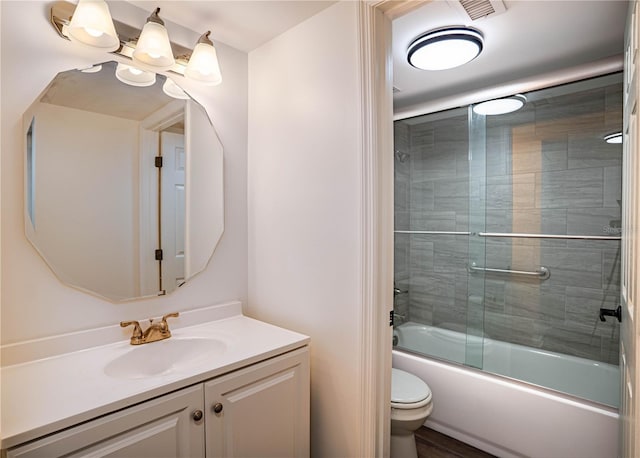 full bathroom featuring toilet, visible vents, combined bath / shower with glass door, and vanity