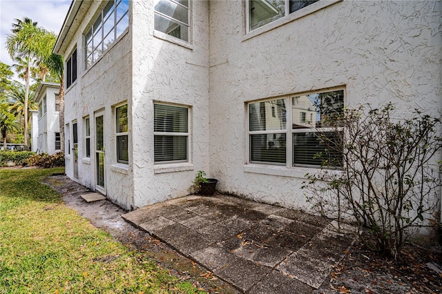 view of property exterior featuring a yard, a patio, and stucco siding