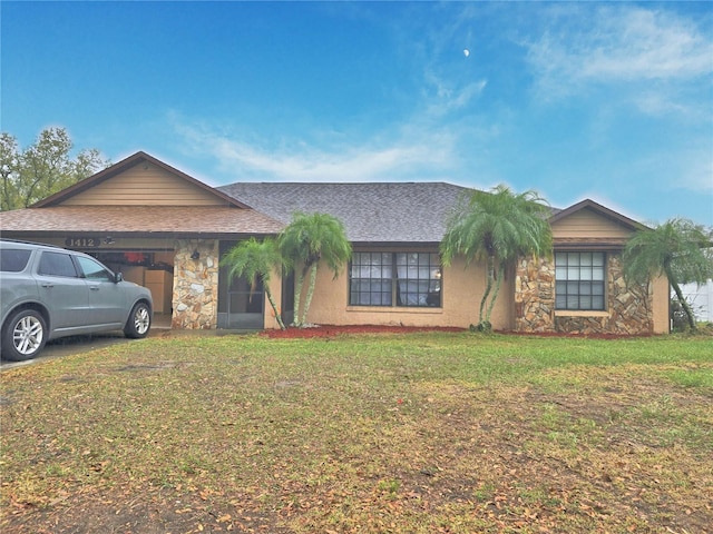 ranch-style home featuring an attached garage, stone siding, a shingled roof, and a front lawn