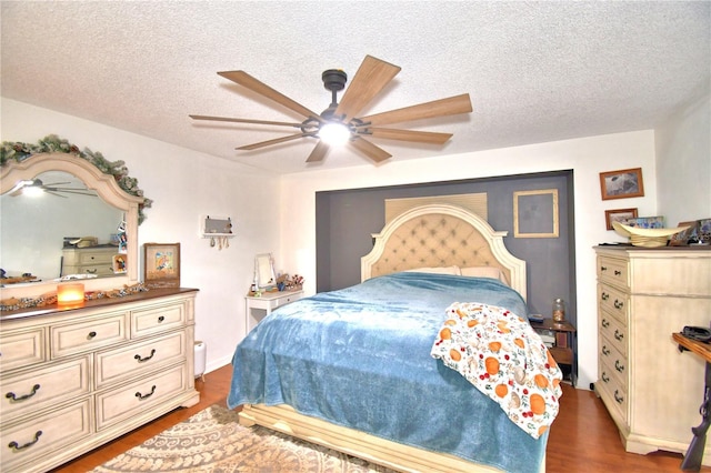 bedroom with a ceiling fan, dark wood finished floors, and a textured ceiling