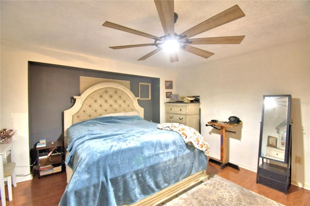 bedroom featuring a textured ceiling, dark wood finished floors, a ceiling fan, and baseboards