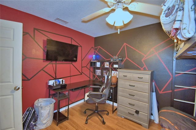 office area featuring visible vents, a textured ceiling, wood finished floors, and a ceiling fan