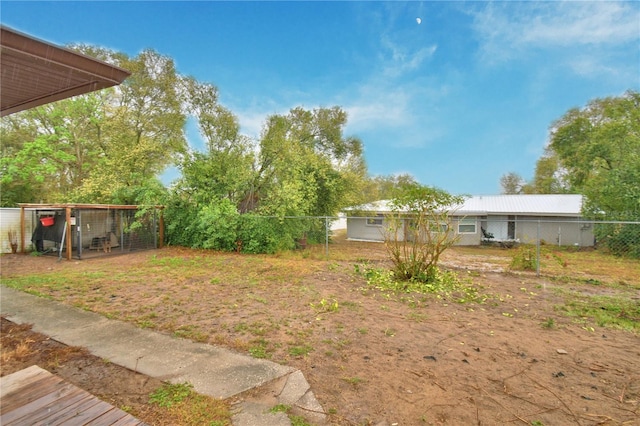 view of yard featuring fence, exterior structure, and an outdoor structure