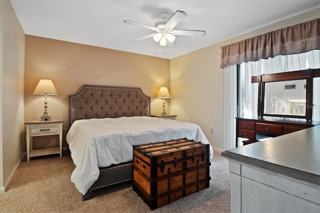 bedroom with a ceiling fan, light carpet, and baseboards