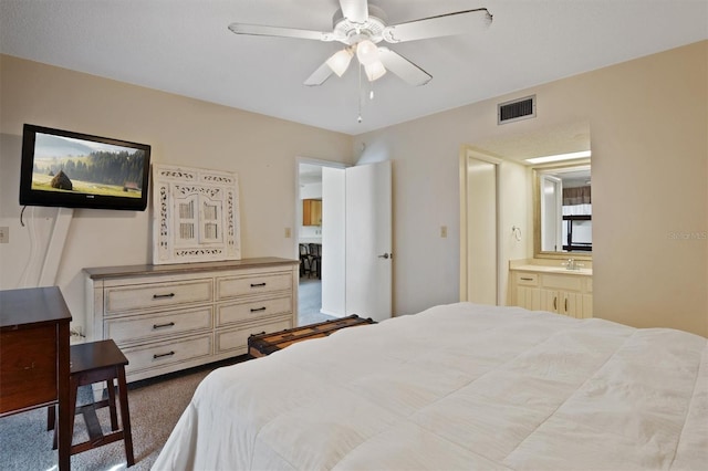 bedroom with connected bathroom, a sink, a ceiling fan, visible vents, and dark colored carpet