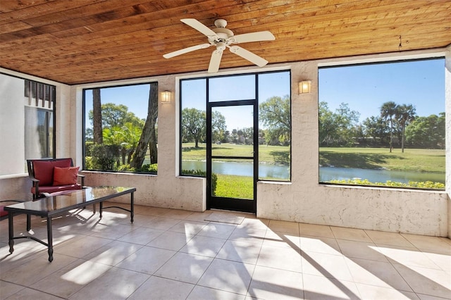 unfurnished sunroom with ceiling fan, a water view, and wood ceiling