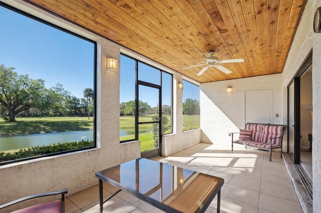 sunroom / solarium with a water view, wood ceiling, and ceiling fan