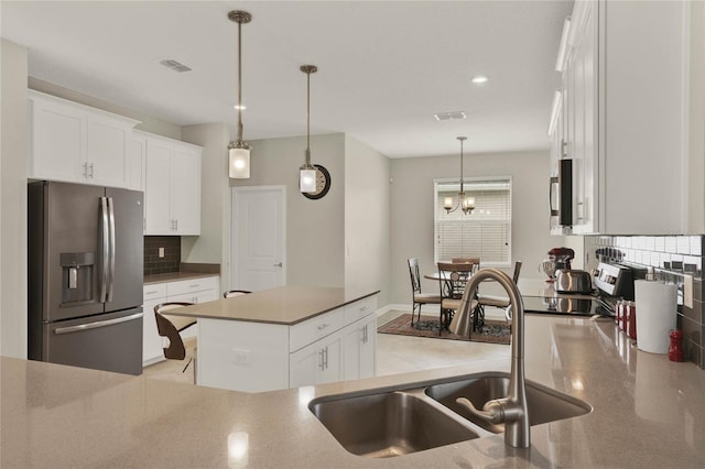 kitchen featuring visible vents, white cabinetry, stainless steel appliances, and a sink