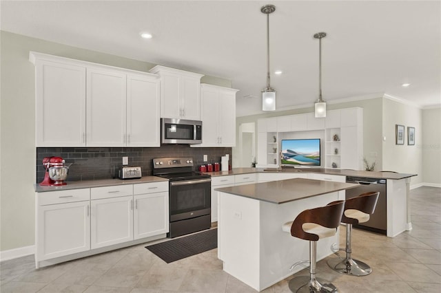 kitchen with pendant lighting, appliances with stainless steel finishes, a breakfast bar, and white cabinets