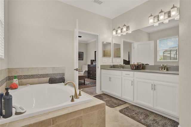 full bathroom with a sink, double vanity, a garden tub, and visible vents