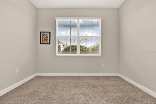 unfurnished room with carpet and baseboards