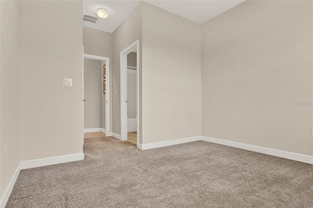 unfurnished room featuring carpet, visible vents, and baseboards