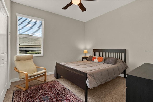 bedroom with a ceiling fan, light carpet, and baseboards