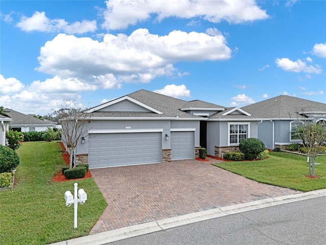 ranch-style house featuring a garage, a front yard, and stucco siding