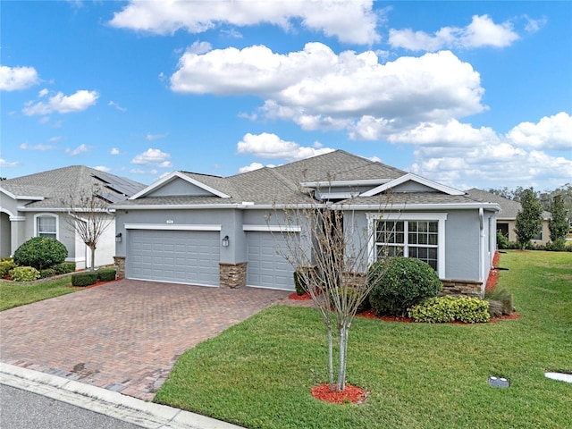 single story home with a garage, stone siding, and a front yard