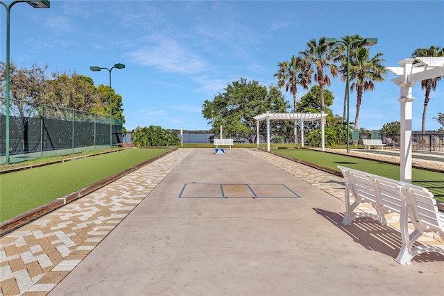 view of property's community featuring fence and a pergola