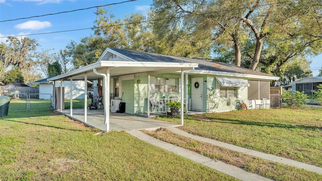 view of front of home with a gate, fence, a front lawn, and an attached carport