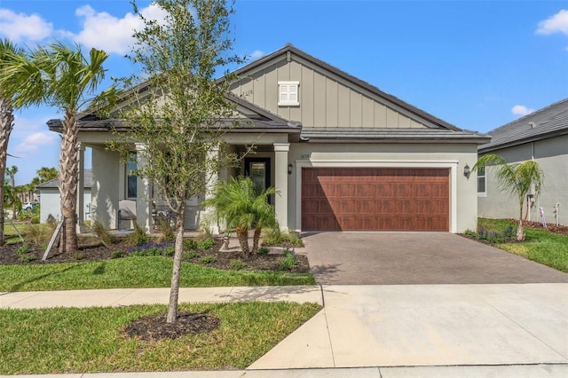 craftsman inspired home with a garage, decorative driveway, board and batten siding, and stucco siding