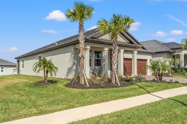 view of front of property with a garage, driveway, metal roof, a front lawn, and stucco siding