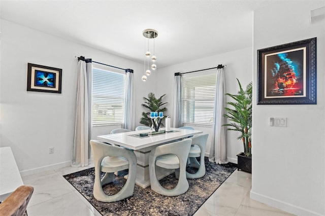 dining area with marble finish floor, baseboards, and a wealth of natural light