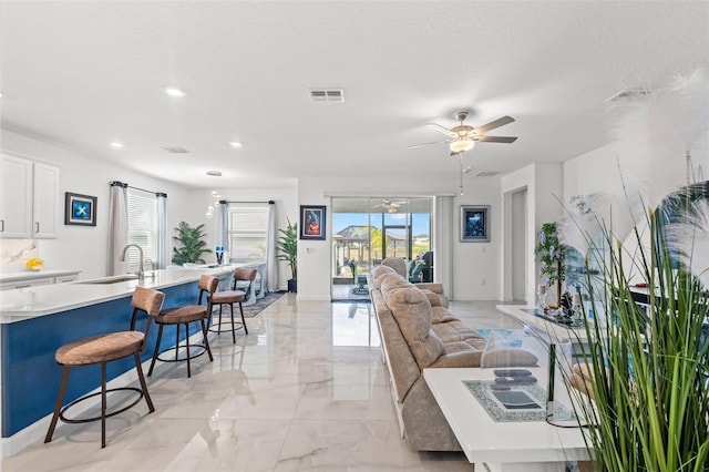 living area featuring marble finish floor, recessed lighting, visible vents, ceiling fan, and a textured ceiling