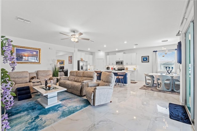 living area featuring marble finish floor, ceiling fan, visible vents, and recessed lighting