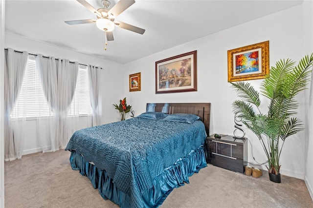 bedroom featuring ceiling fan, baseboards, and light colored carpet