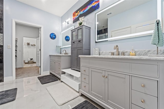 bathroom featuring two vanities, marble finish floor, visible vents, and a sink