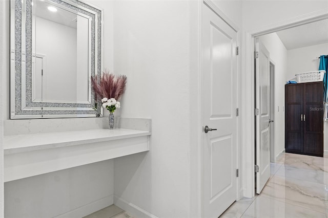 bathroom with marble finish floor and baseboards