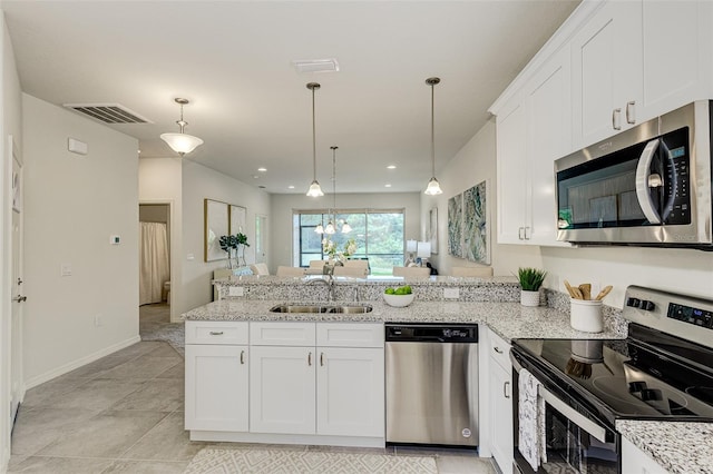 kitchen with visible vents, a peninsula, stainless steel appliances, white cabinetry, and a sink