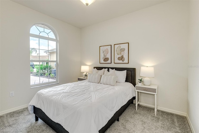 bedroom featuring light colored carpet and baseboards