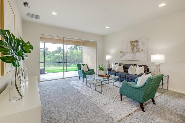 carpeted living room featuring baseboards, visible vents, and recessed lighting